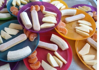 Kolorowe talerze z owocami i biszkoptami na stole.